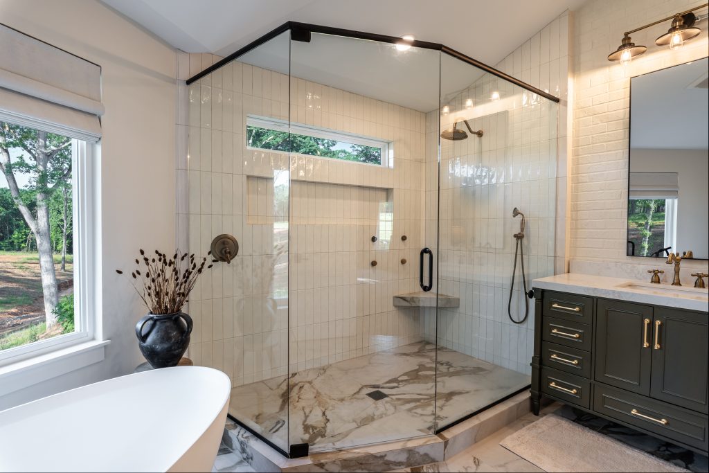 master bathroom with large shower that has glass walls and white tile walls
