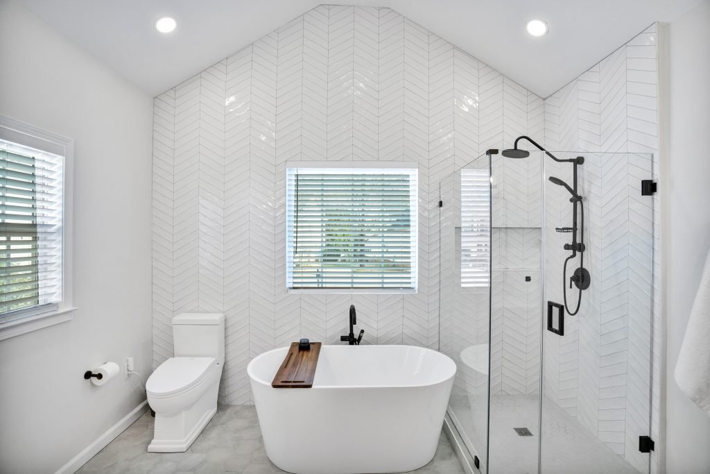 the new master bathroom with a white tub, bathtub, shower in a gut home renovation