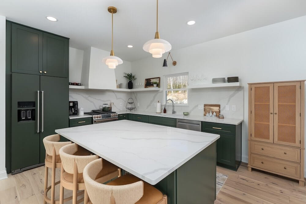 remodeled kitchen by kamanski construction with dark green cabinets and marble countertops