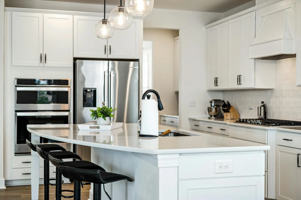 newly remodeled kitchen with white cabinets, quartz kitchen countertops, and black fixtures