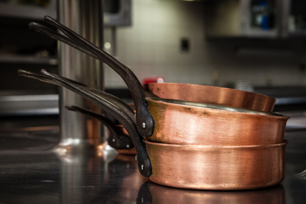 copper cooking pans on stainless steel kitchen countertops