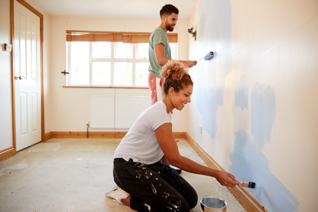 african american couple painting a home