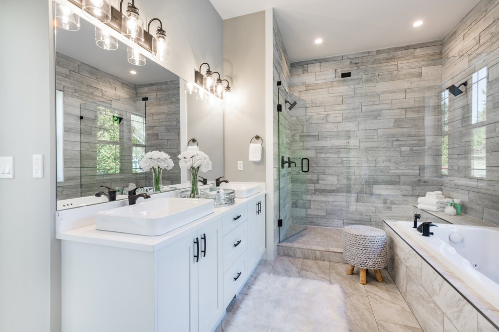 white and grey bathroom with soft lighting and white cabinetry